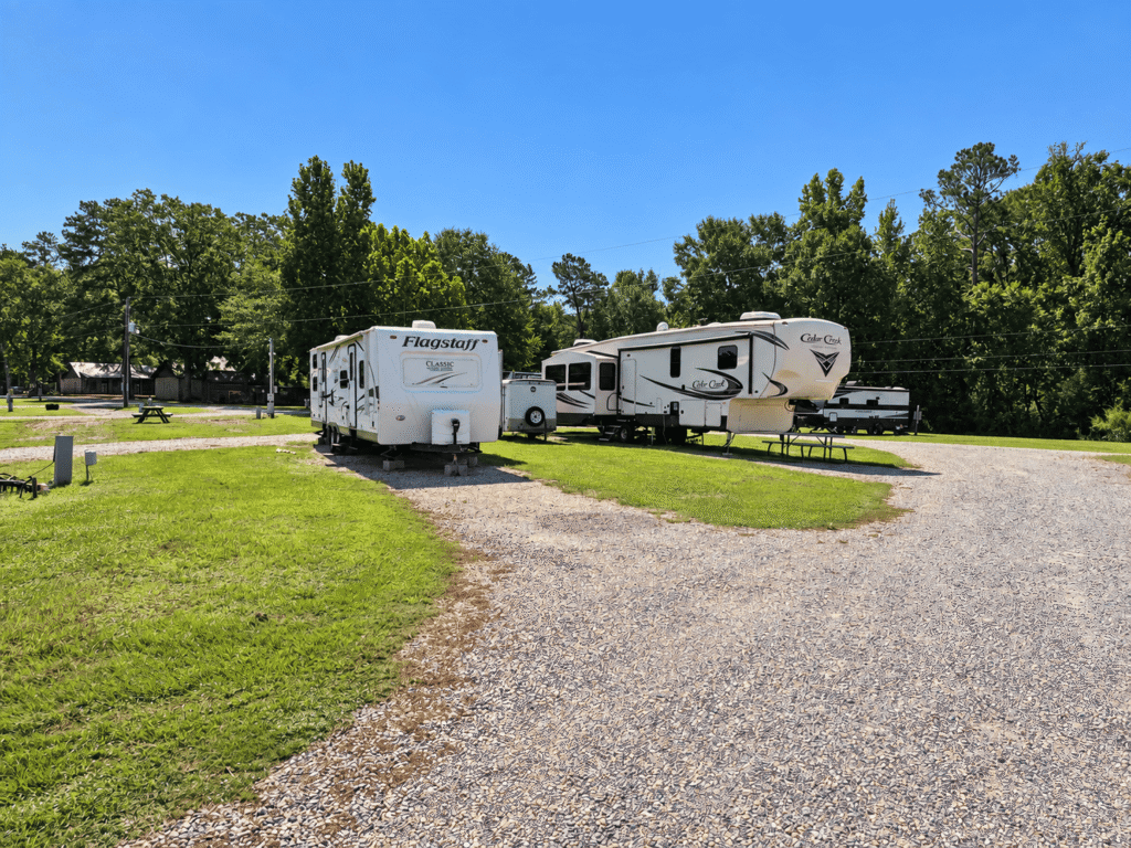 Spacious RV sites with travel trailers parked on level gravel pads.